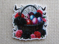First view of a black Easter basket covered in spider webs with black butterflies and black and red roses.
